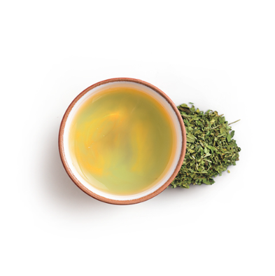 Cup of peppermint tea with leaves on the side